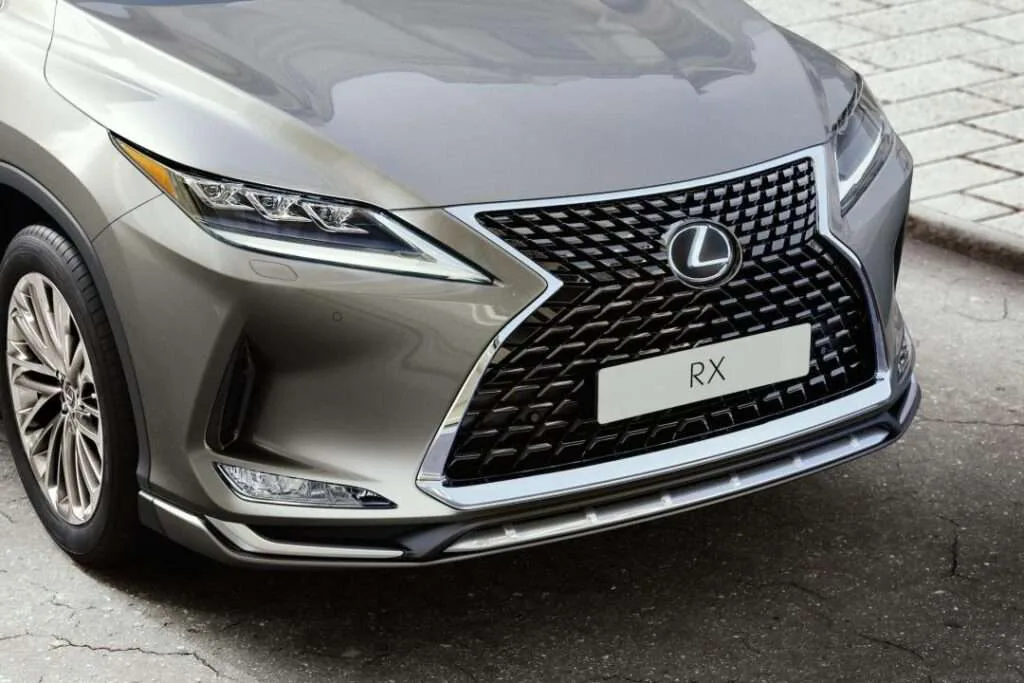 Close-up of a new battery being installed in a Lexus engine bay
