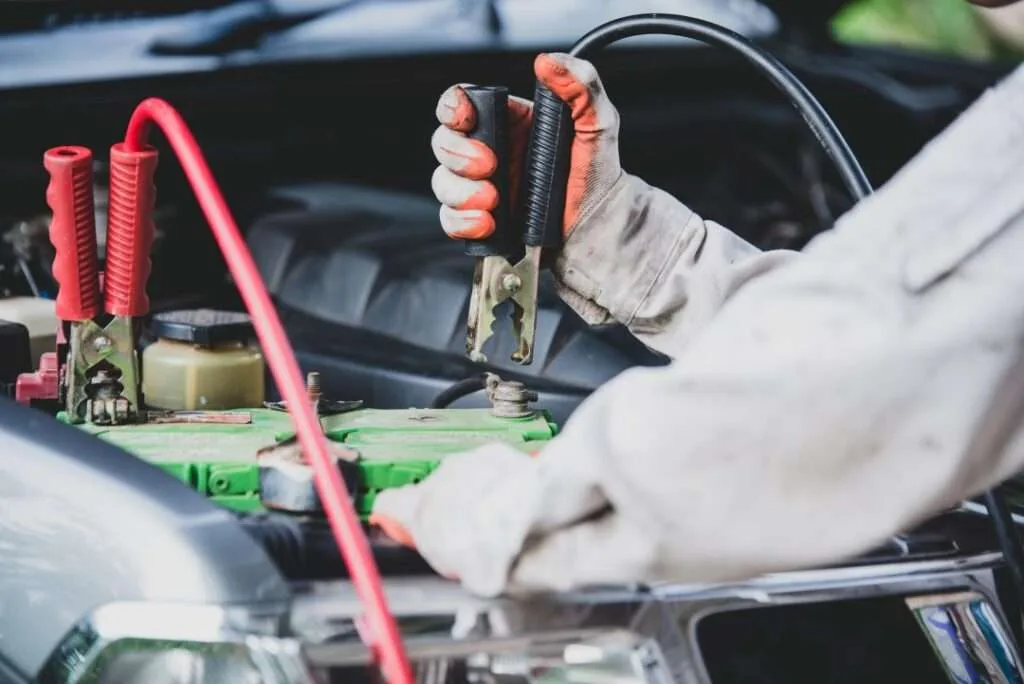 Expert technician replacing a battery in a Jaguar vehicle with care and precision