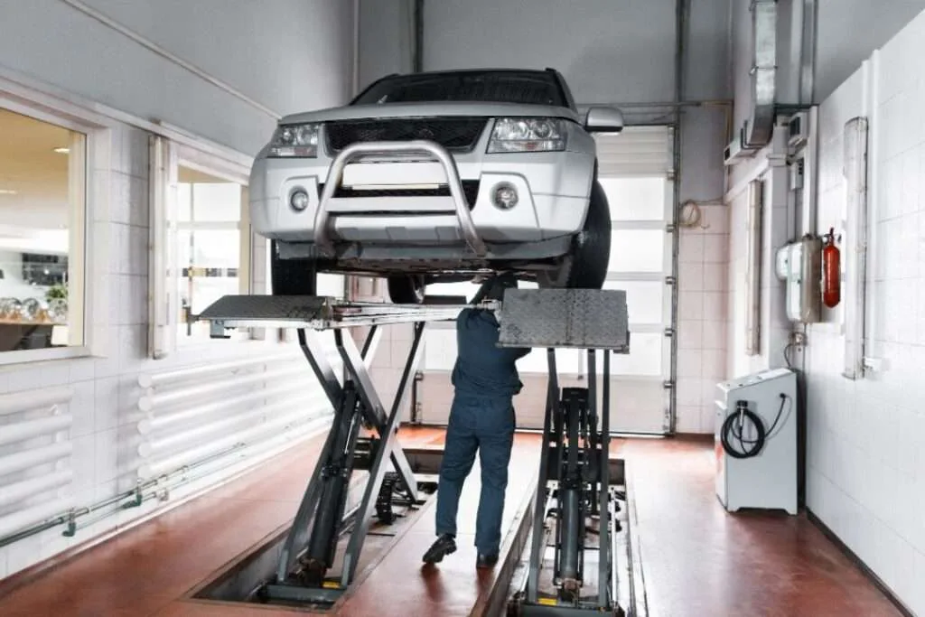 Mechanic installing new battery during Land Rover battery replacement