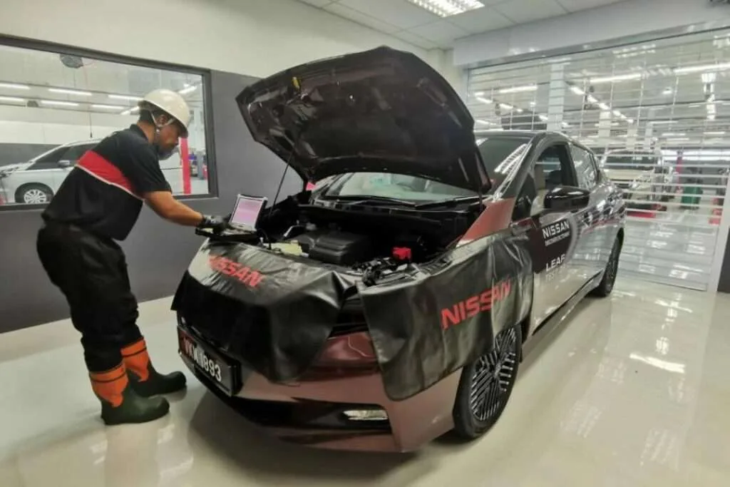 Nissan car with hood open during battery check and replacement