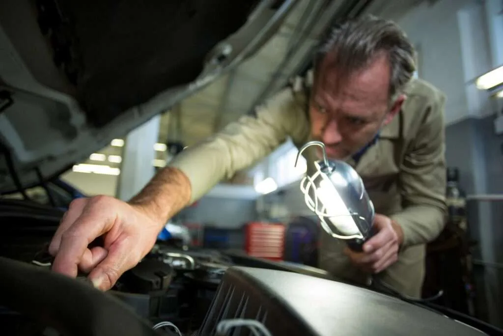 Expert technician replacing the battery of a Rolls-Royce with precision and care